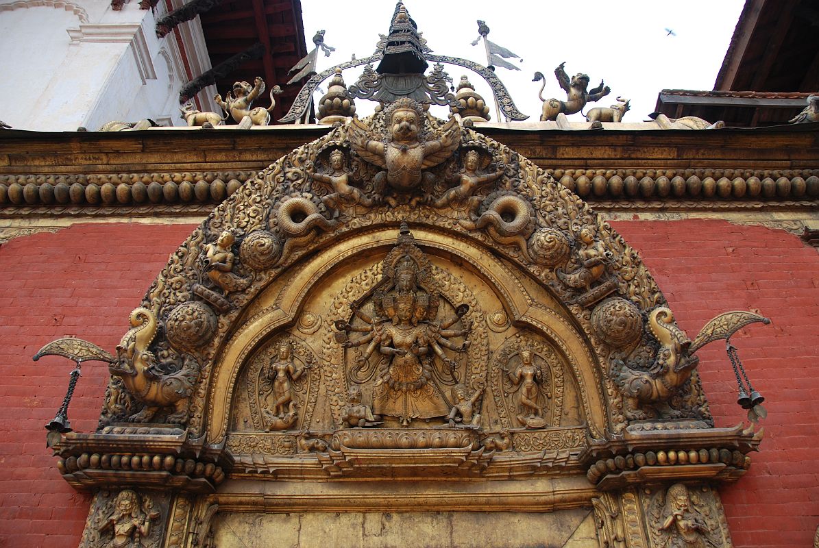 Kathmandu Bhaktapur 04-2 Bhaktapur Durbar Square Golden Gate Torana With Garuda And Taleju Bhawani A garuda tops the torana, disposing of a number of serpents, at the Golden Gate in Bhaktapur�s Durbar Square. The four-headed and 10-armed figure of the goddess Taleju Bhawani is directly above the door.